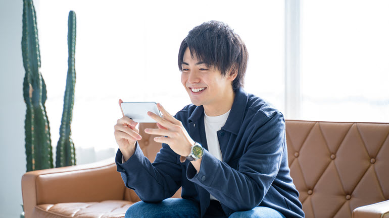 Japanese person watching localized videos on mobile at home
